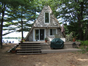 The same cottage with cultured stone veneer installed on it.