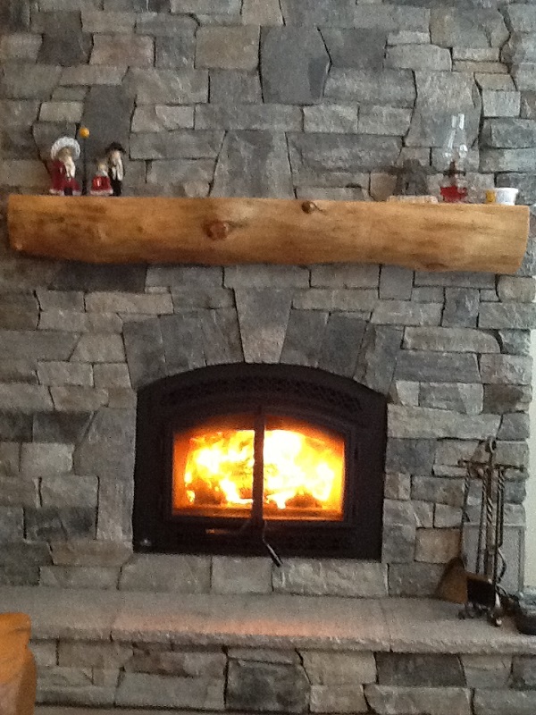 The roaring fire seen in this granite stone veneer fireplace