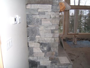 Side view of granite veneer fireplace during construction.