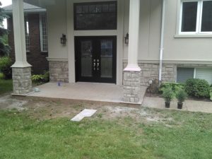 An entrance containing two pillars with cultured stone