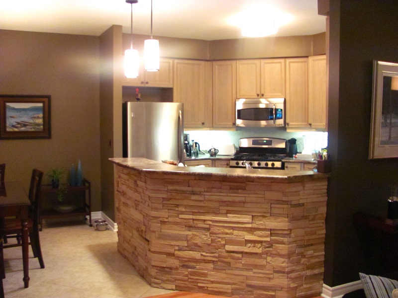 Kitchen peninsula with application of profit cultured stone.