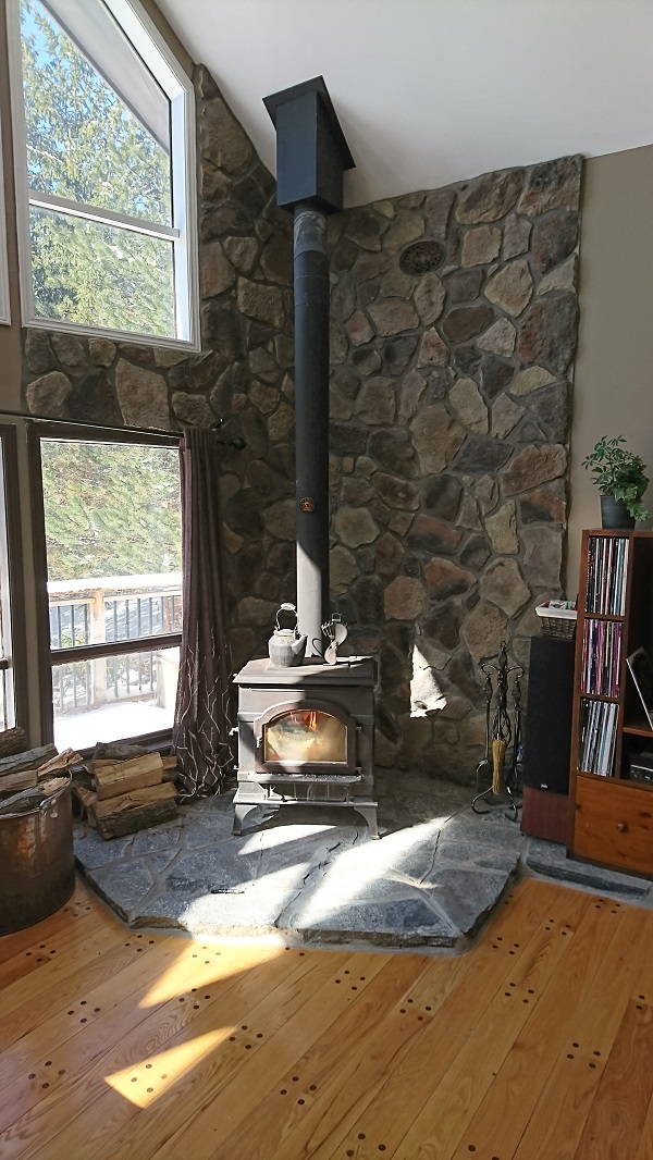 Wood stove with stone veneer wall.