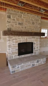 Thin cut stone veneer fireplace with vertical stone feature.