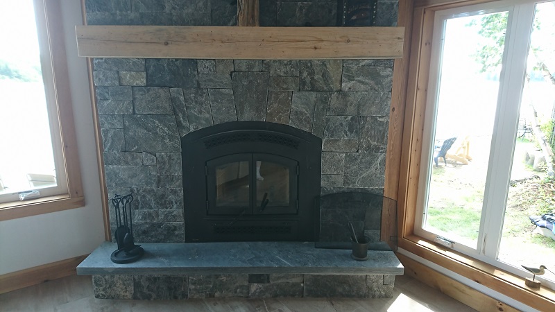 Granite veneer fireplace with feature.