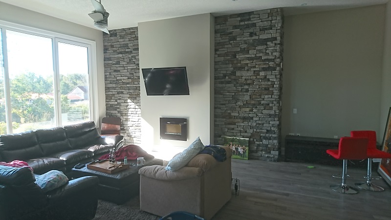 Living room featuring stone veneer accent walls.