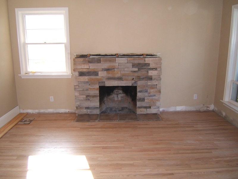 Brick fireplace resurfaced with stone veneer.