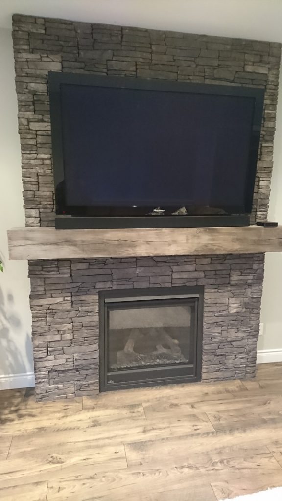 Front view of Farmledge Westchester stone veneer by Stonecraft surrounding a gas fireplace.