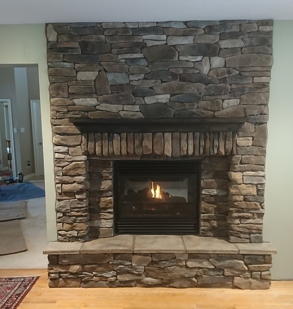 Stone veneer fireplace with dry stack pattern.