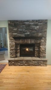 Completed accent wall with recessed gas fireplace.